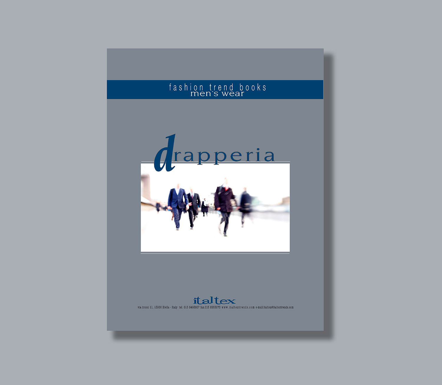 A blue and grey cover for the men's wear trend book Menswear Drapperia, with a blurred image of people walking along a street