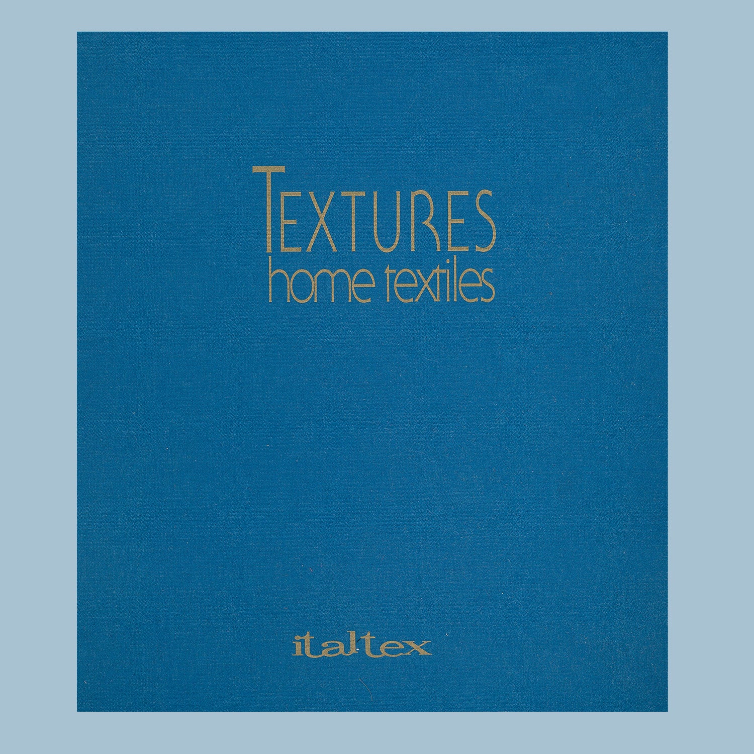 Canvas blue filer with golden title: Textures home textiles - Italtex